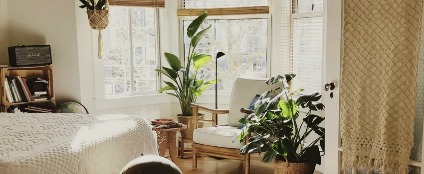Cottagecore inspired bedroom filled with green plants and handwoven linens.